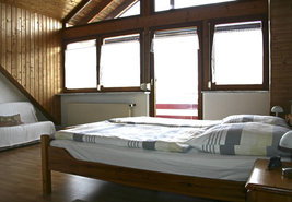 Vom großzügigen Schlafzimmer mit Doppelbett geht es auf den Balkon.